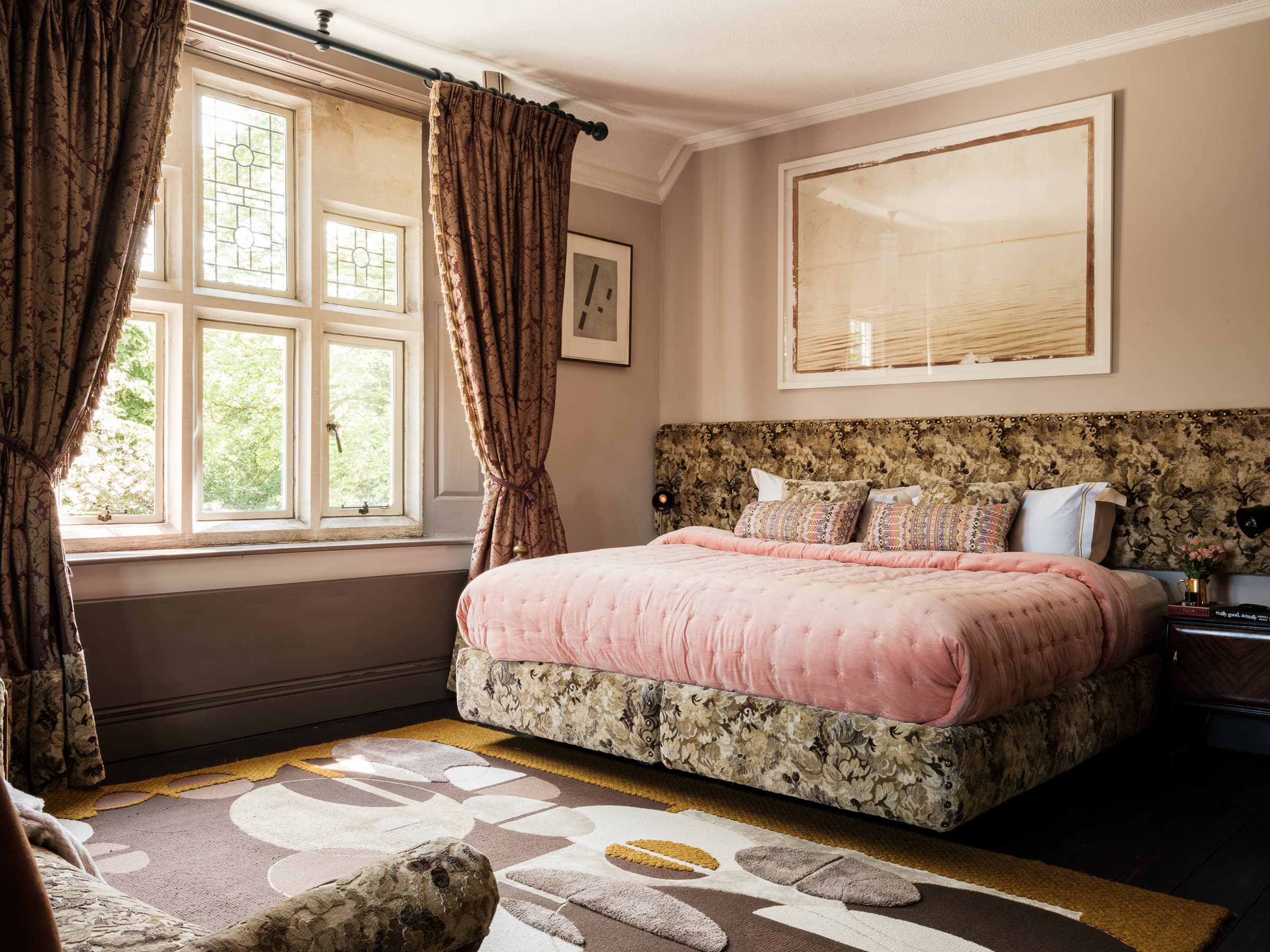 Somerleaze bedroom with pink bedspread, stained glass windows