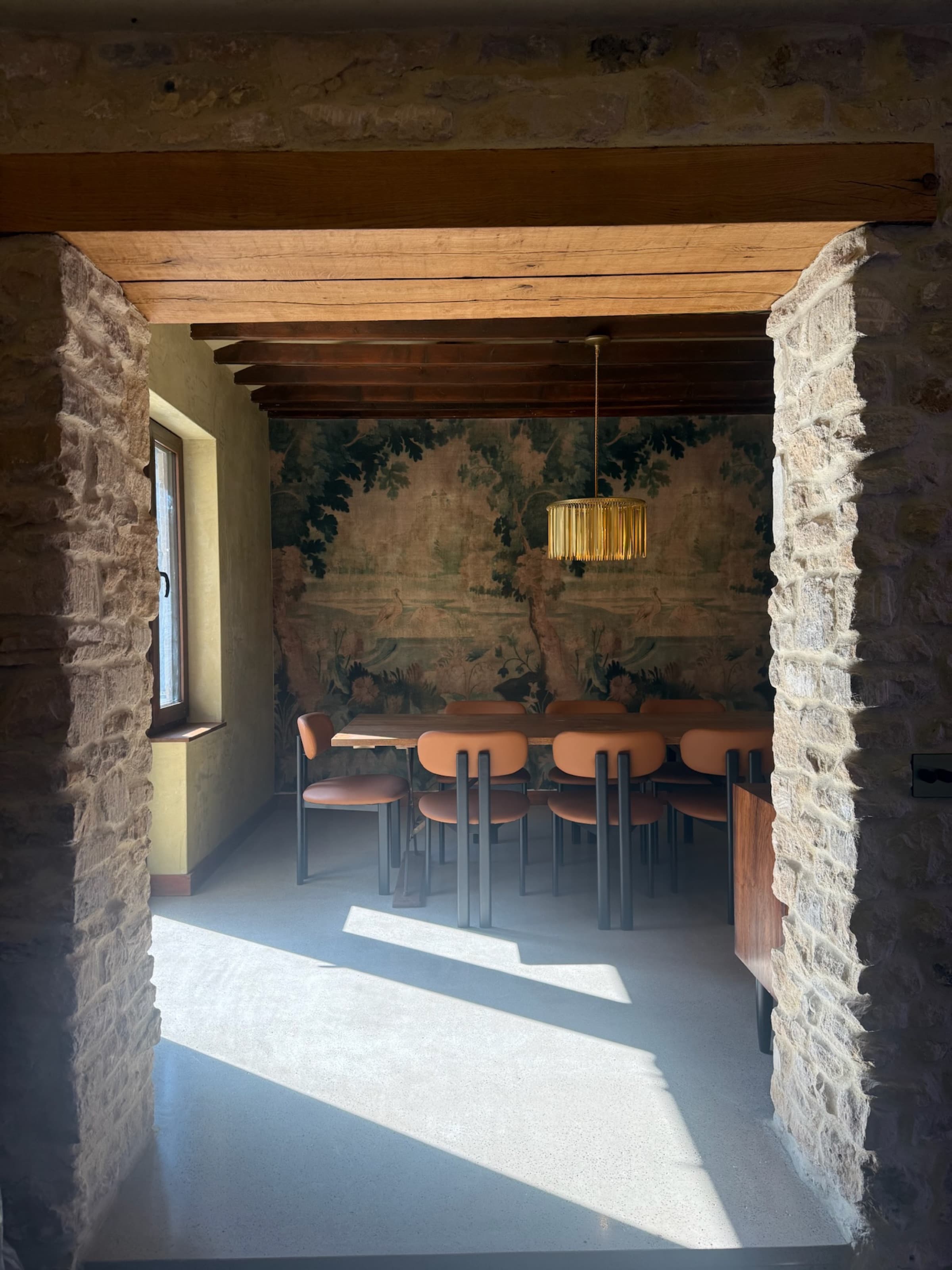 Tapestry dining room framed through stone archway