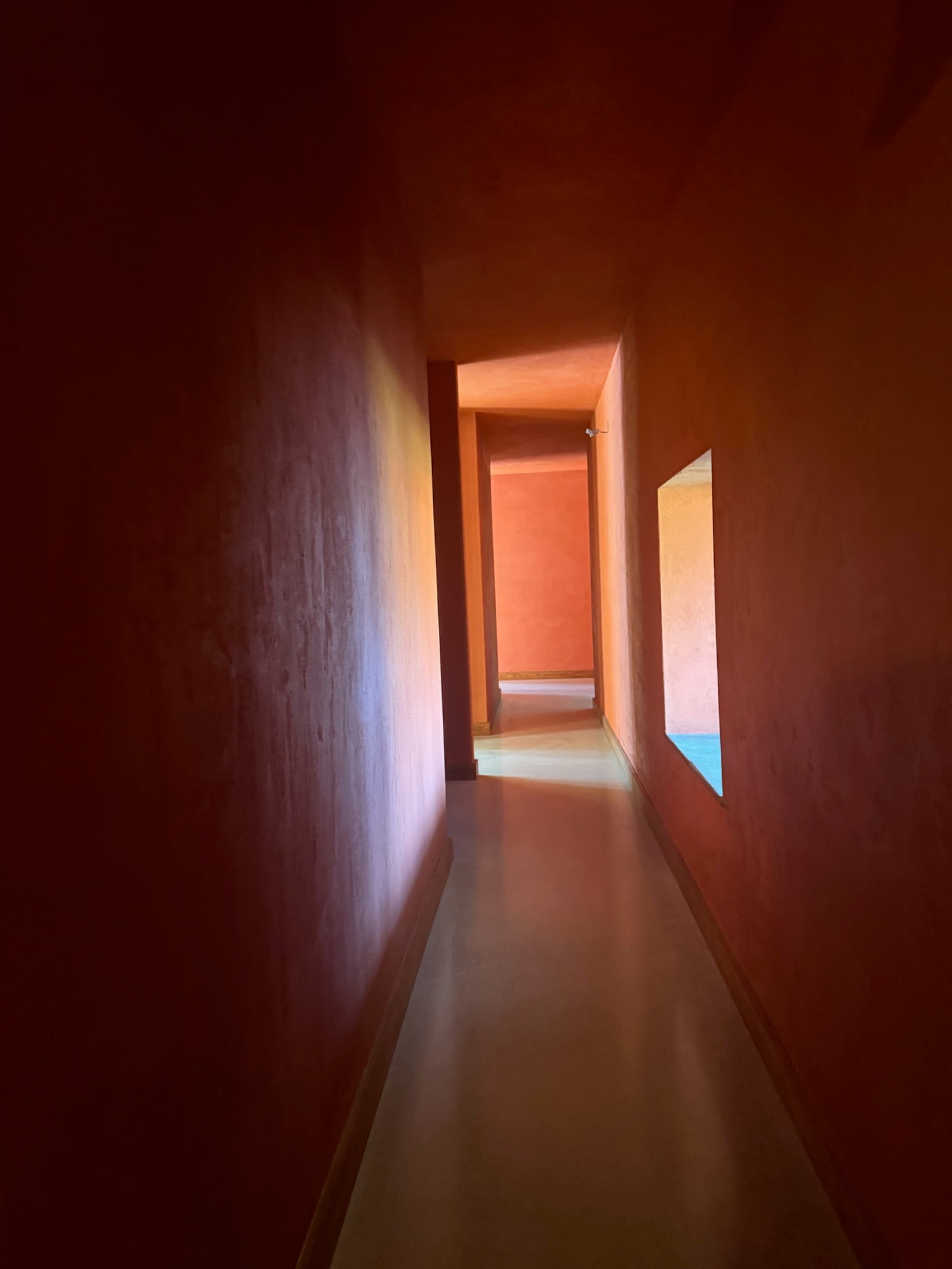 Hallway, deep terracotta render, limestone floor