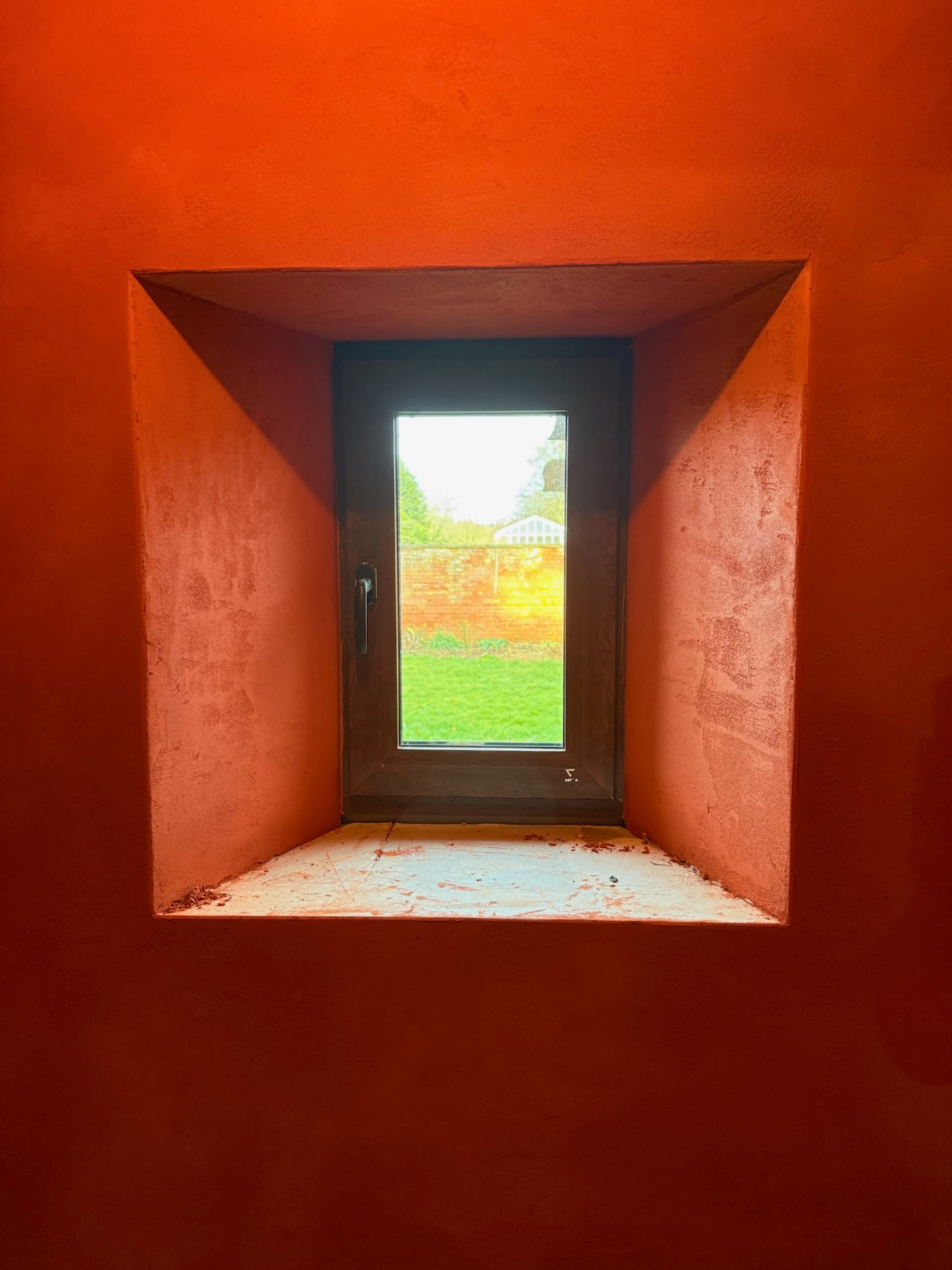 Deep-set window in terracotta render wall