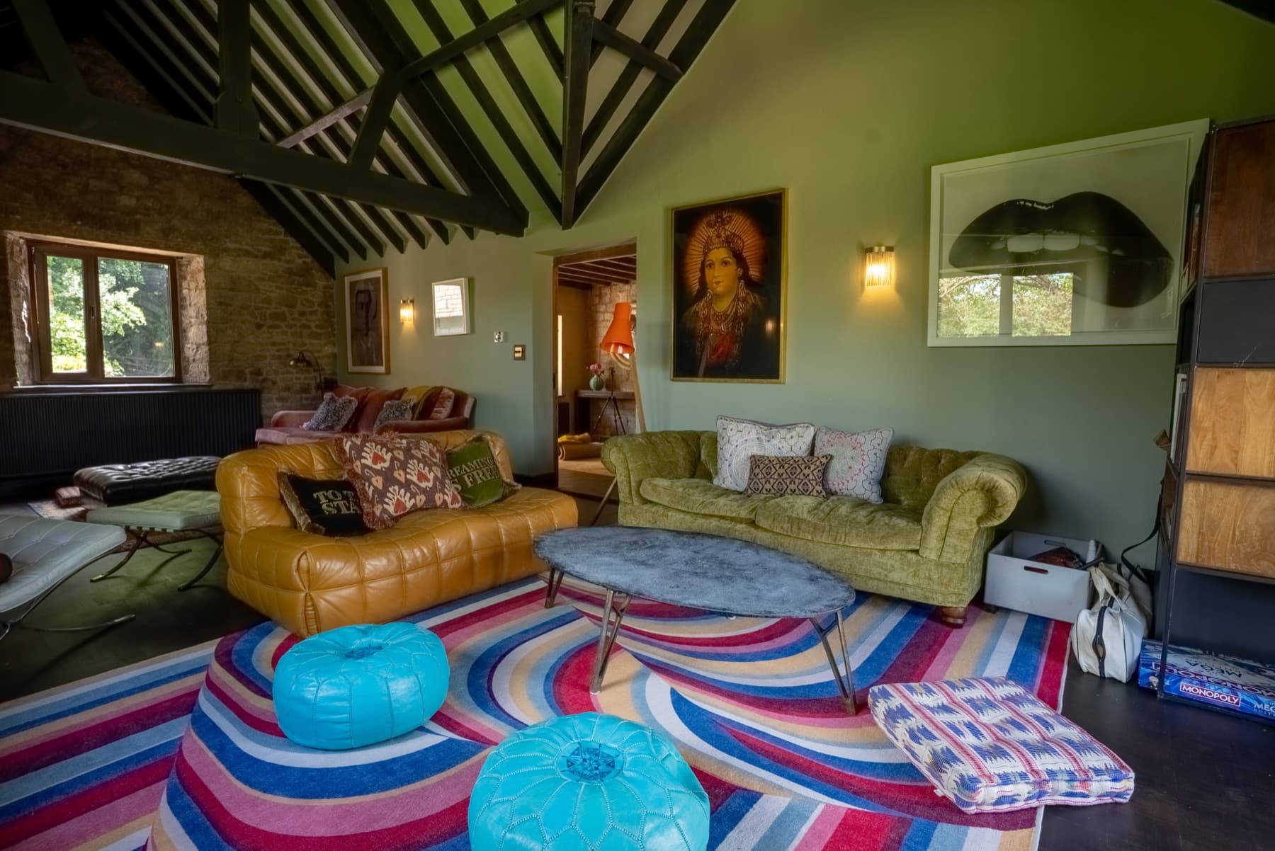 Living room, leather chesterfield and velvet sofas under vaulted beams