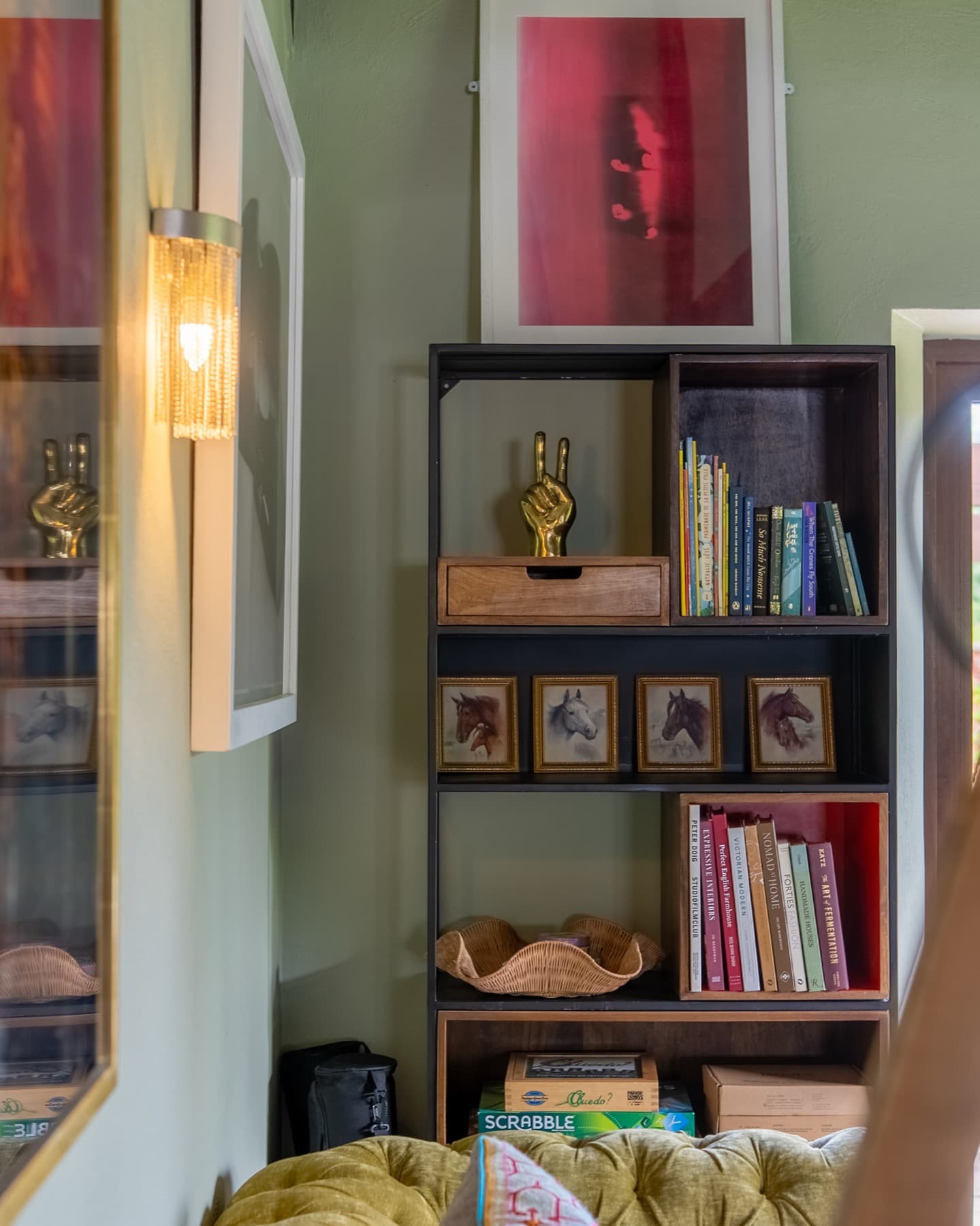 Snug bookshelf corner with horse prints and board games